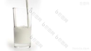 牛奶倒在白色背景的玻璃杯里